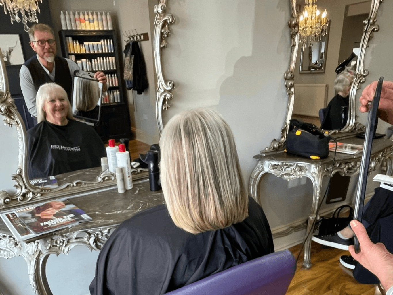 Stylist at Baileys Hairdressing showing a client her finished haircut in the mirror, capturing the friendly, professional atmosphere of this Grantham salon.