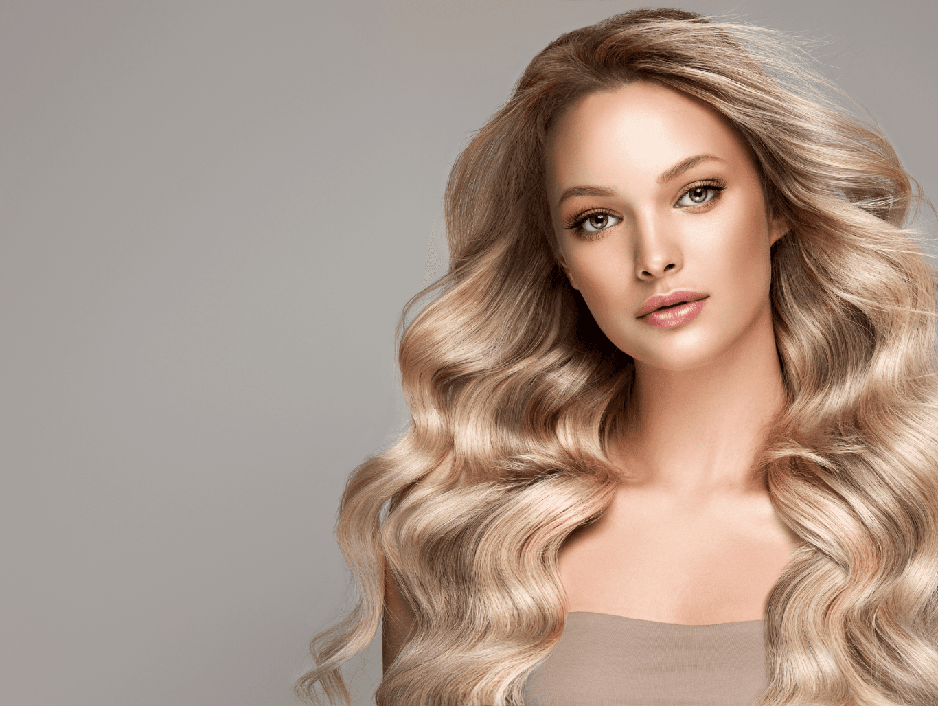 Blonde woman with long, voluminous full head foil highlights at Baileys Hairdressing Grantham, featuring radiant, multi-tonal shine and soft waves.