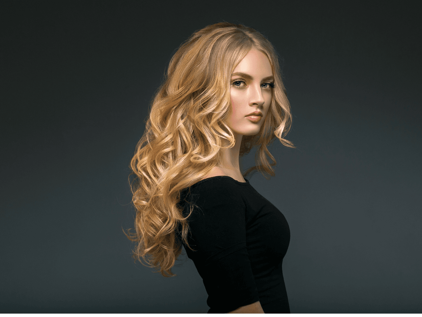 Blonde woman with long, voluminous half head foil highlights styled in soft waves at Baileys Hairdressing Grantham, showcasing radiant, multi-tonal colour.